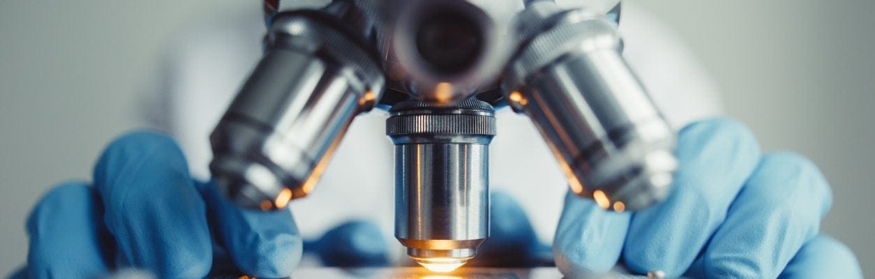 Close up of examining of test sample under the microscope